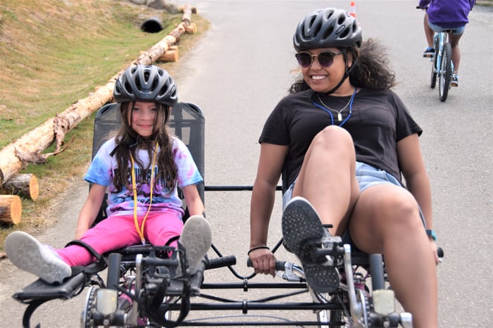 A camper and a counselor bike together at Camp Korey, the SeriousFun camp in Washington.