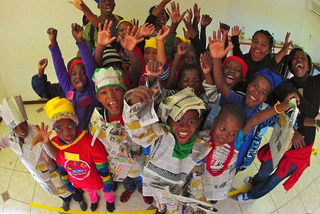 A group of campers with fashion show accessories made of newspaper