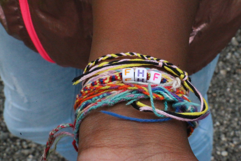 Wrist of camper with yarn bracelets from web of gratitude activity