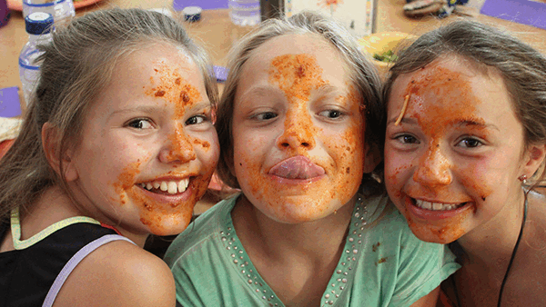 Gif showing campers smiling and waving during mealtime.