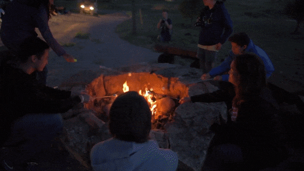 Gif showing campers singing around a campfire.